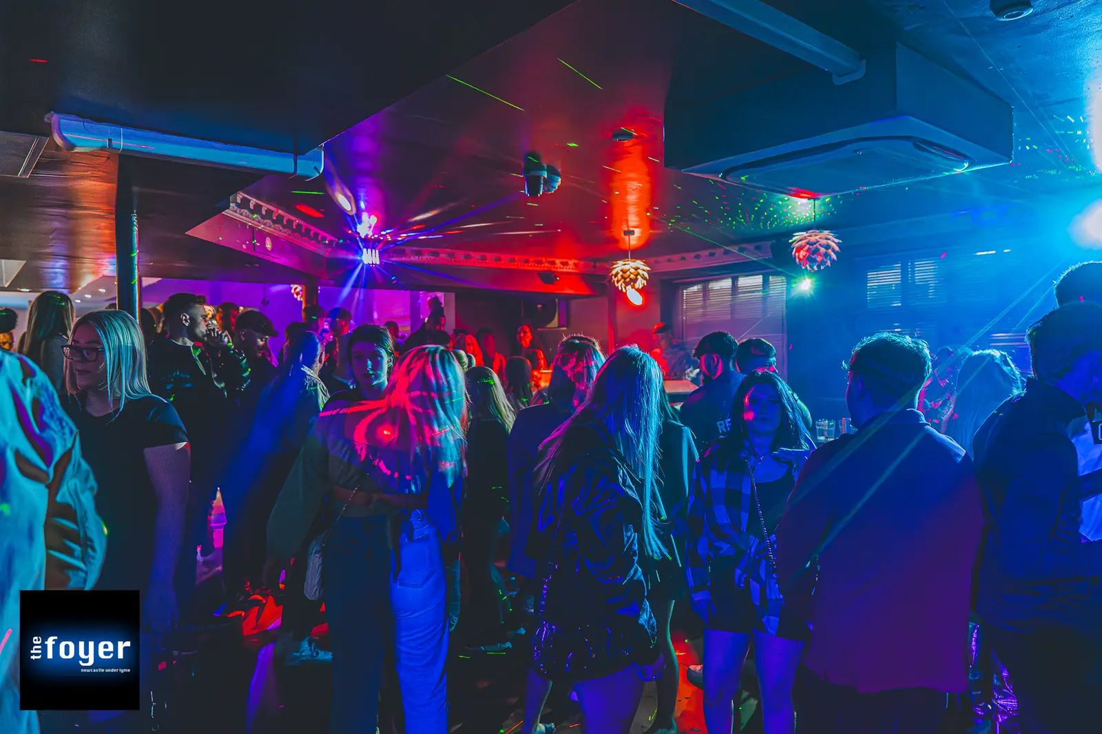 A packed dancefloor at The Foyer under coloured lights